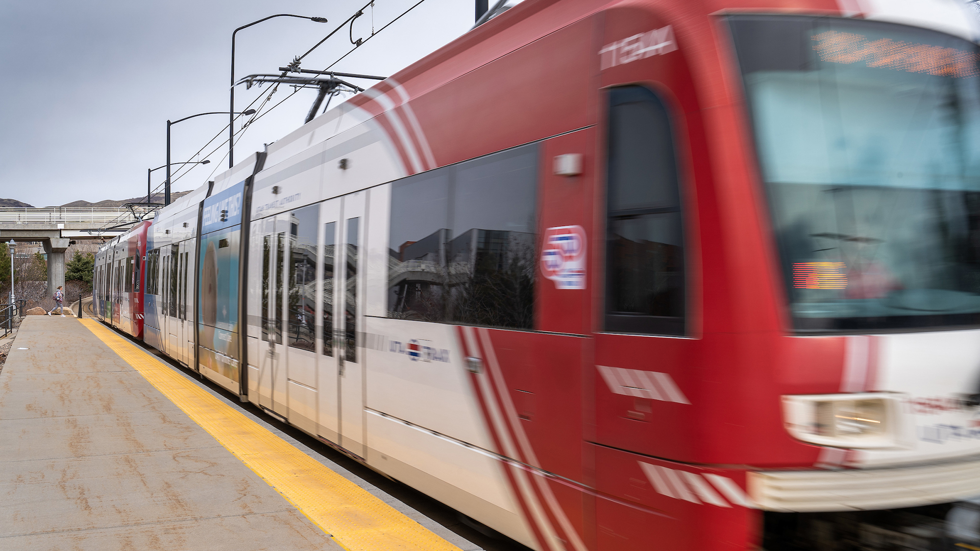 A red and white TRAX light rail train blurred by motion