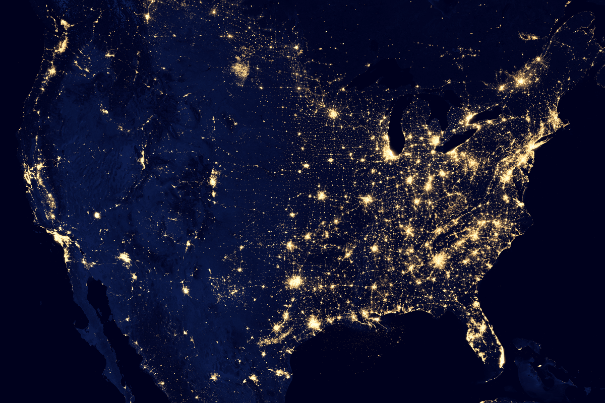 NASA image is a dark blue US map showing bright spots and splashes indicating electrical power.